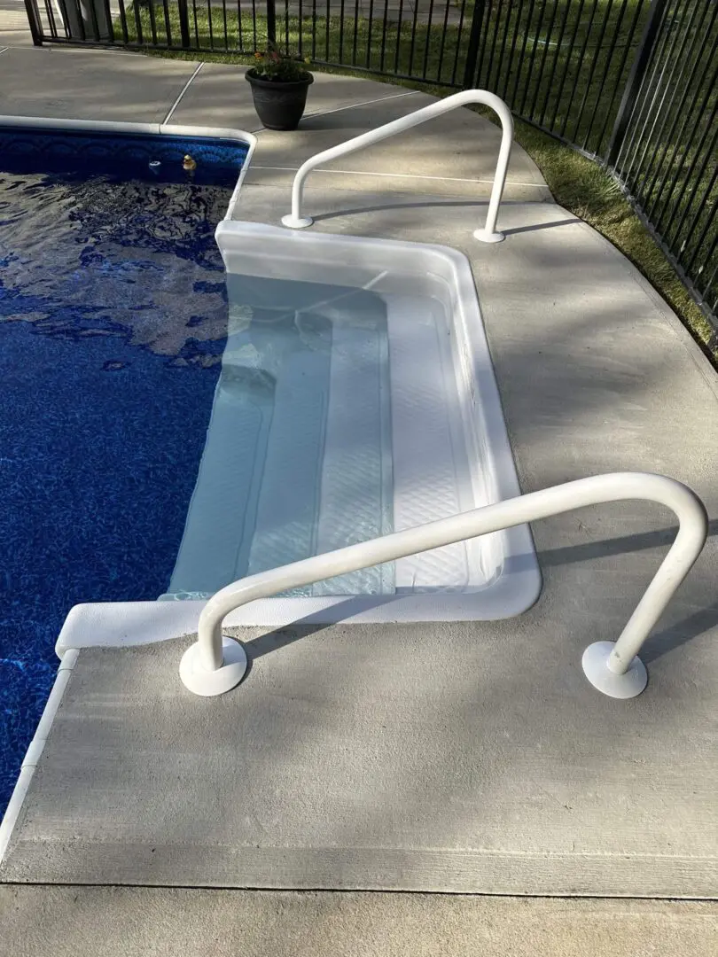 A pool with a ramp and handrails on the side of it.