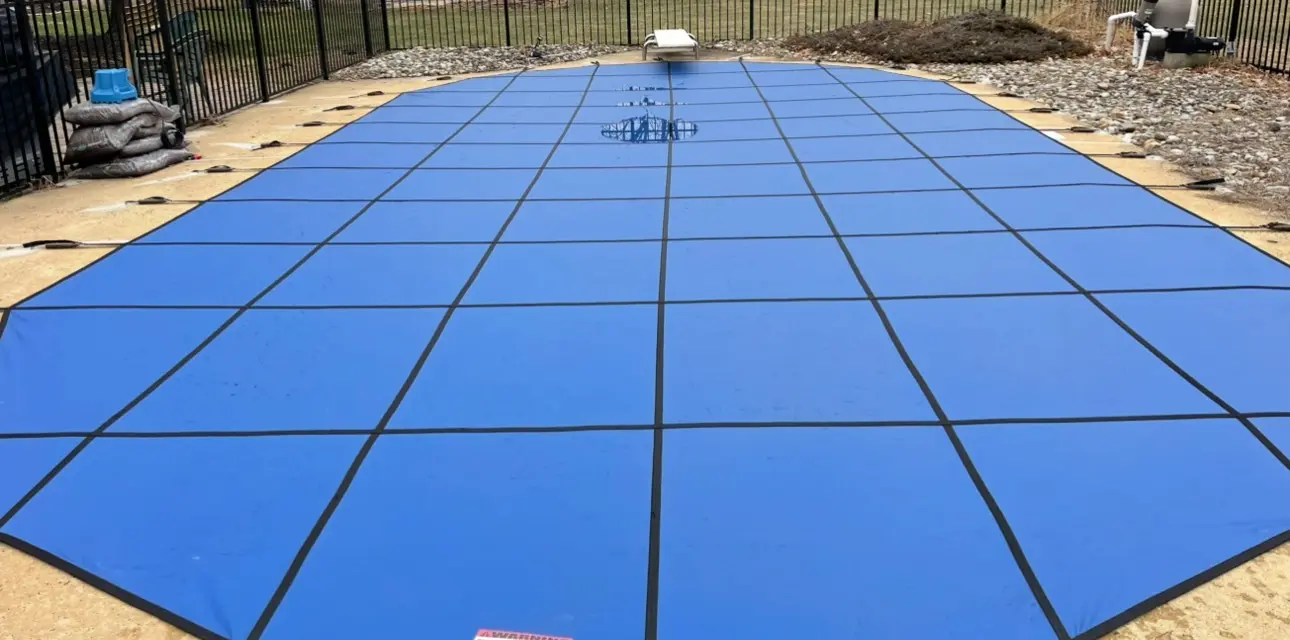A pool cover that is covered in blue tarps.