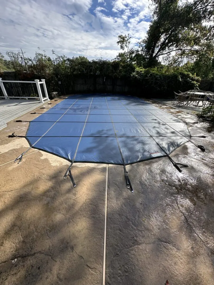 Blue pool cover on a stone patio.