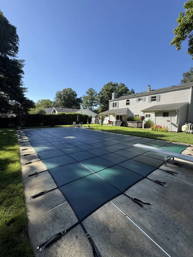 "Green pool cover on a sunny backyard"