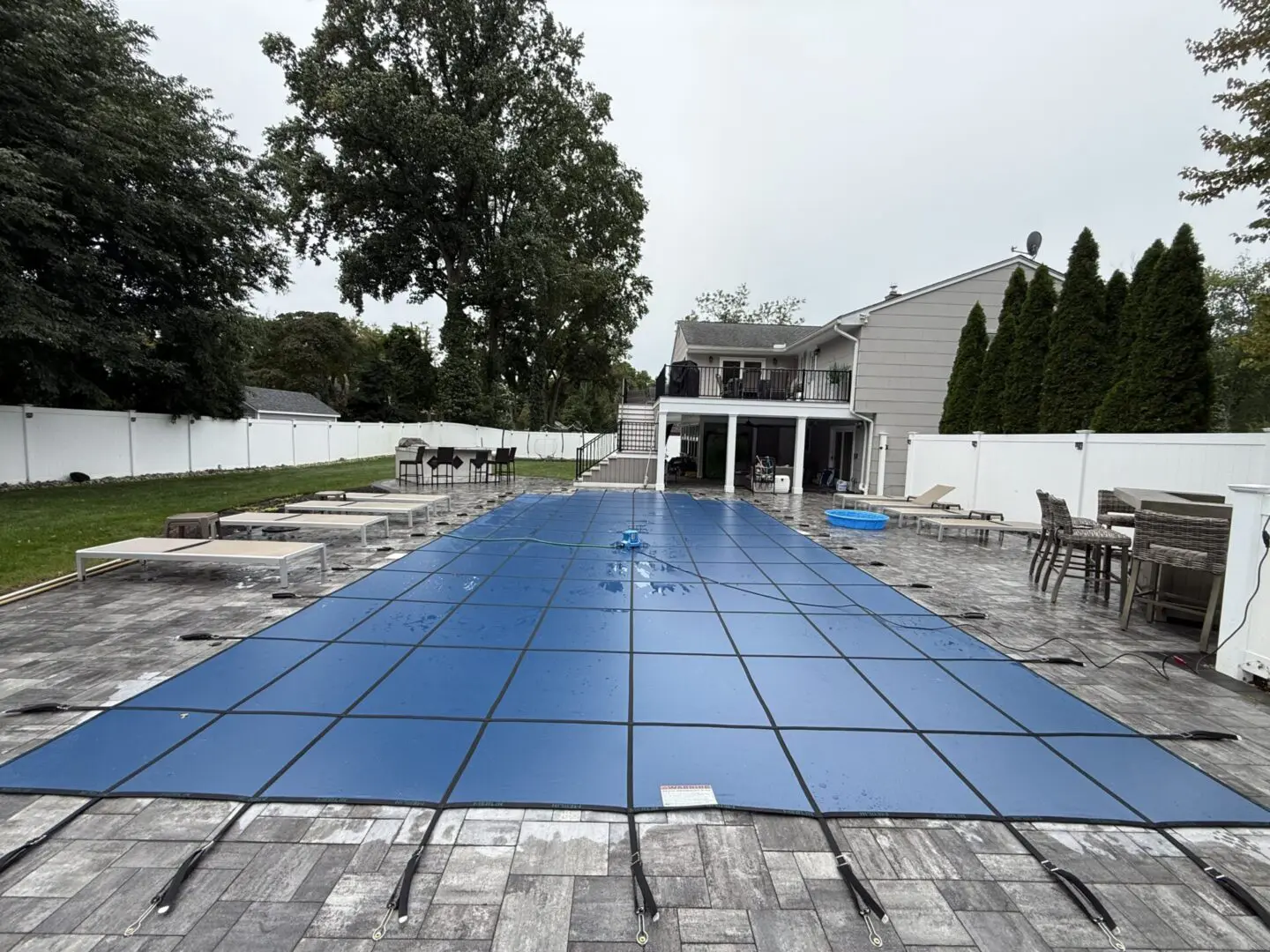Blue pool cover over a patio area.