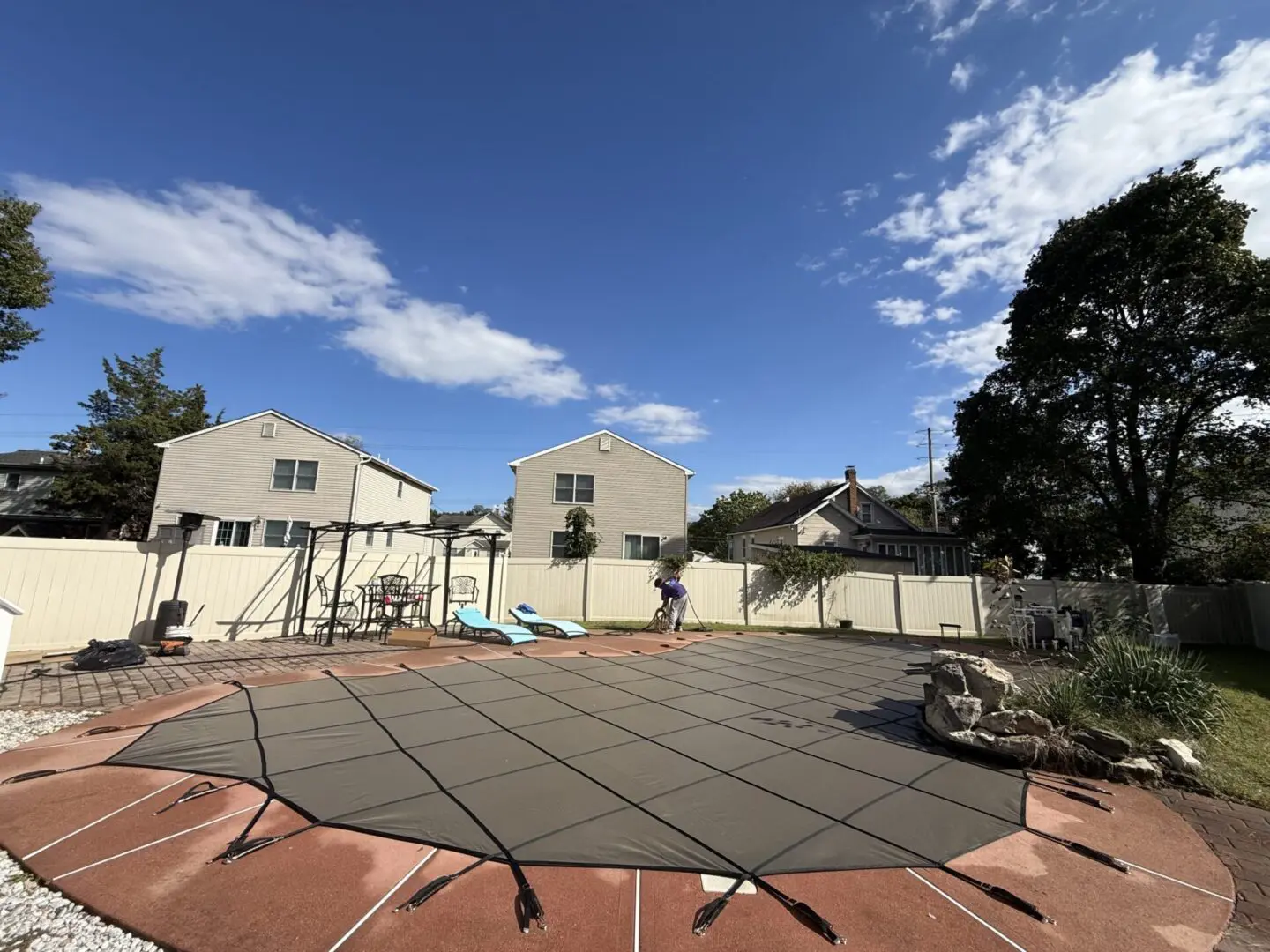 Pool cover stretched across a backyard patio