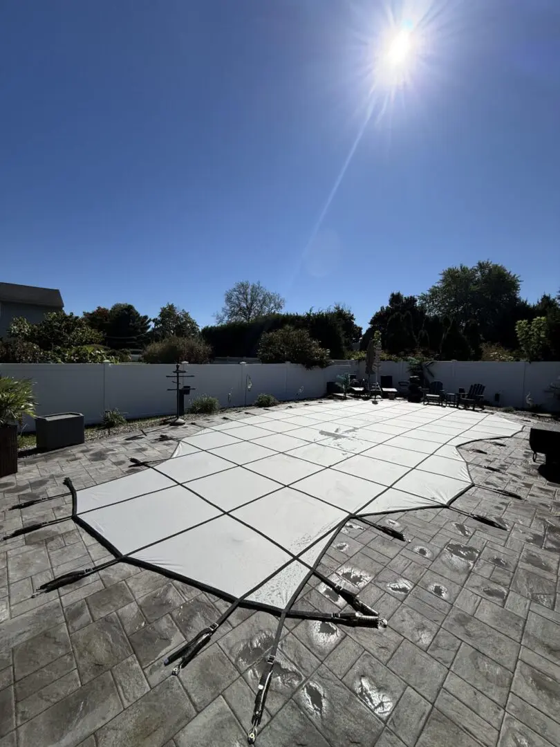 Pool cover spread across a stone patio