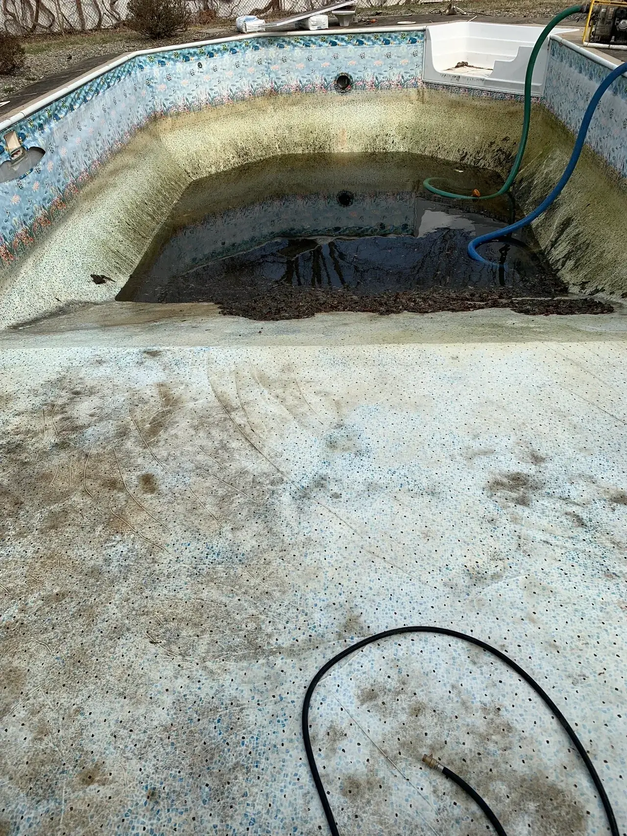 A concrete floor with dirt and water on it.