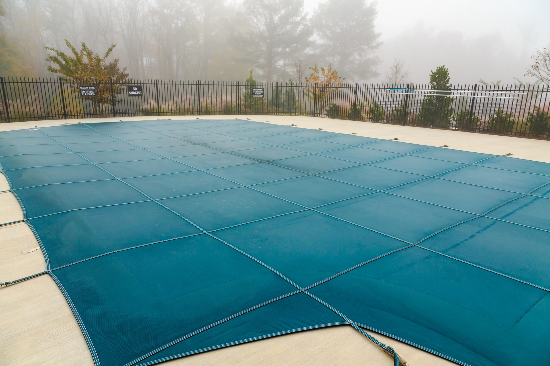 A pool cover that is in the middle of a swimming pool.
