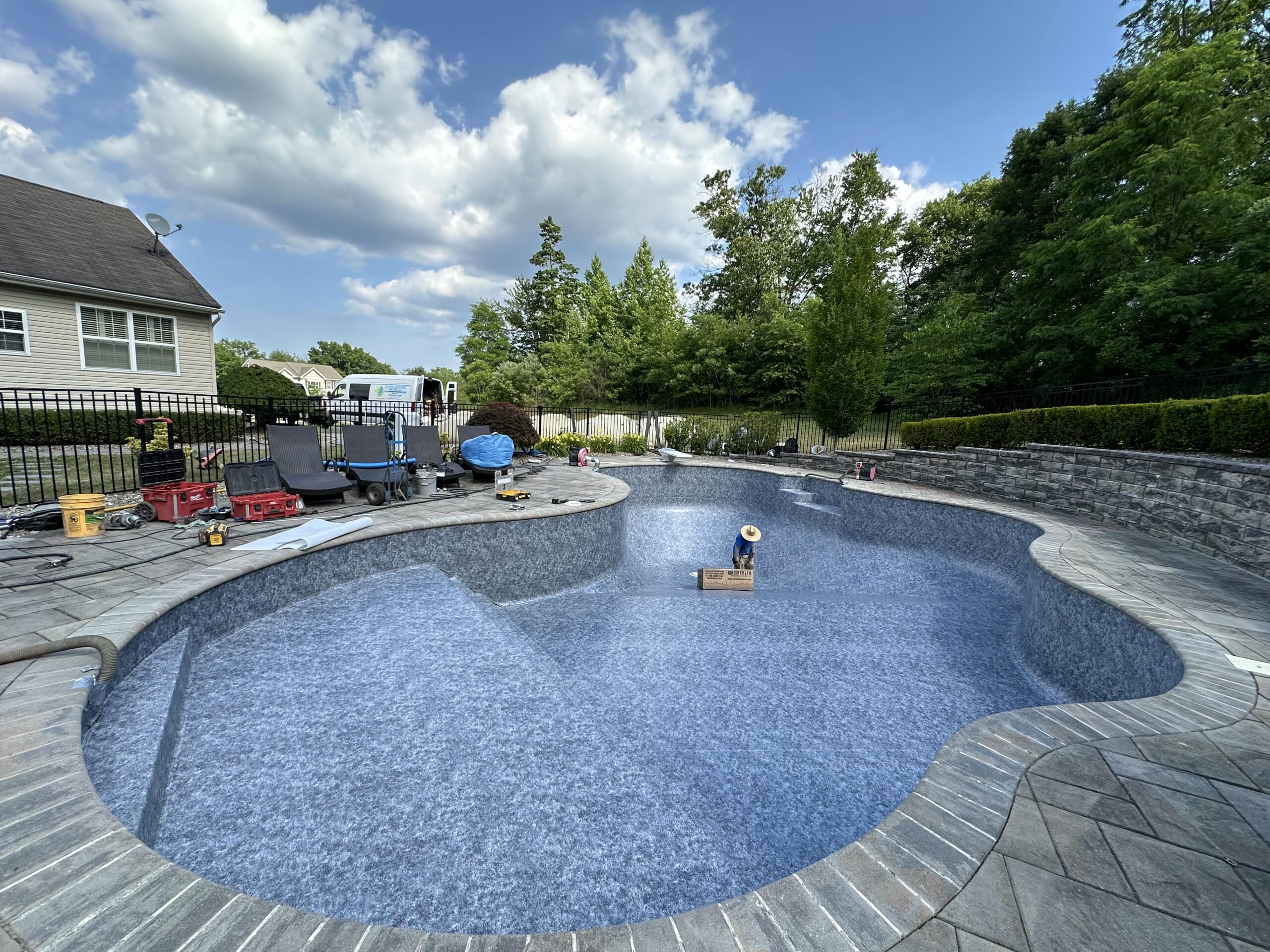 A pool with a man in it and people sitting on the side of it.
